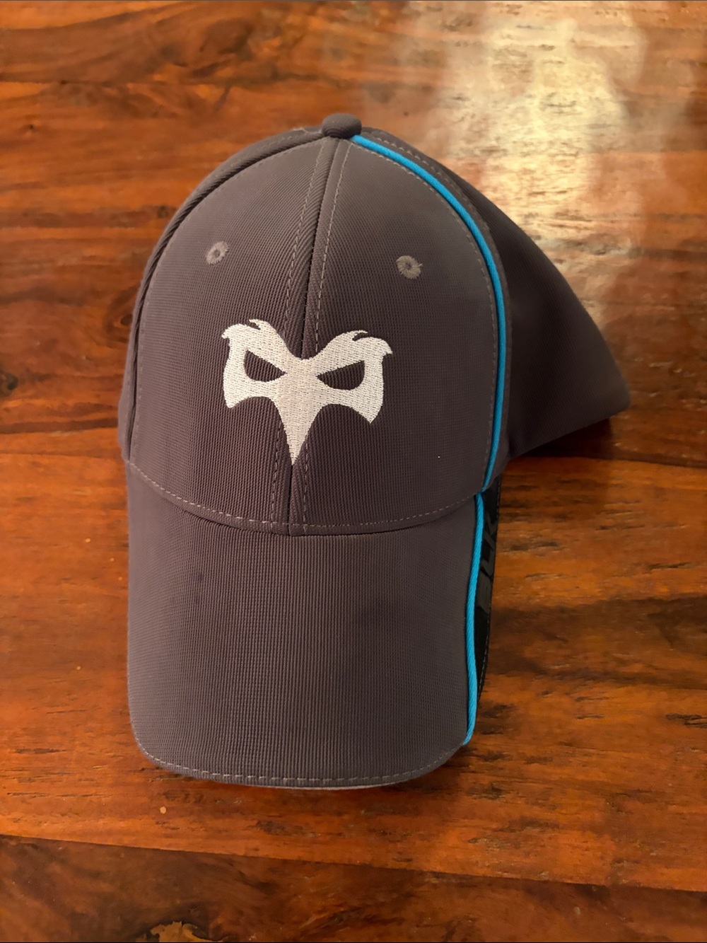 Official Ospreys Rugby Hat. Gray Baseball Cap with Blue Trim and White Mask Logo